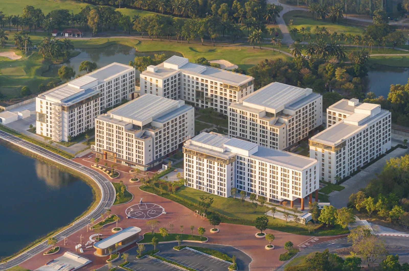 A group of buildings with trees and a pond AI-generated content may be incorrect.